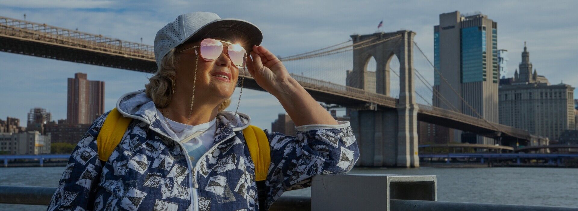 Frau mit Kappe und Sonnenbrille an der Brooklyn Bridge in New York
