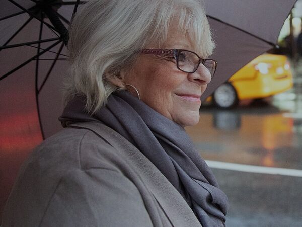 Grinsende Frau mit Regenschirm in New York City